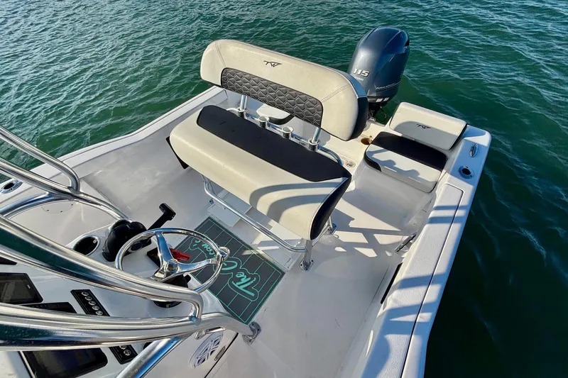 Slide: The Image of 2024 Tidewater 180 CC Adventure boat interior with seating and steering wheel on water. - 16