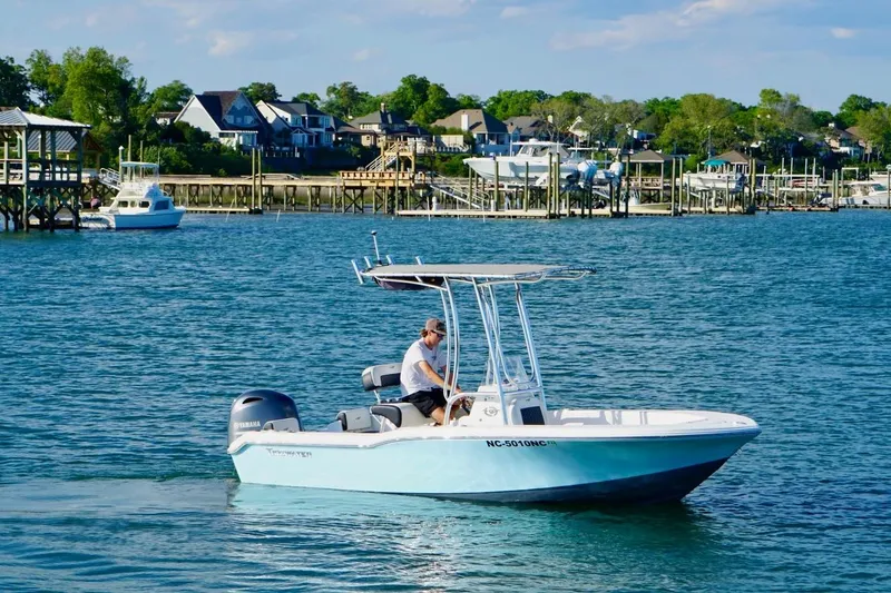 Slide: The Image of 2024 Tidewater 180 CC Adventure boat cruising on a scenic waterfront. - 4