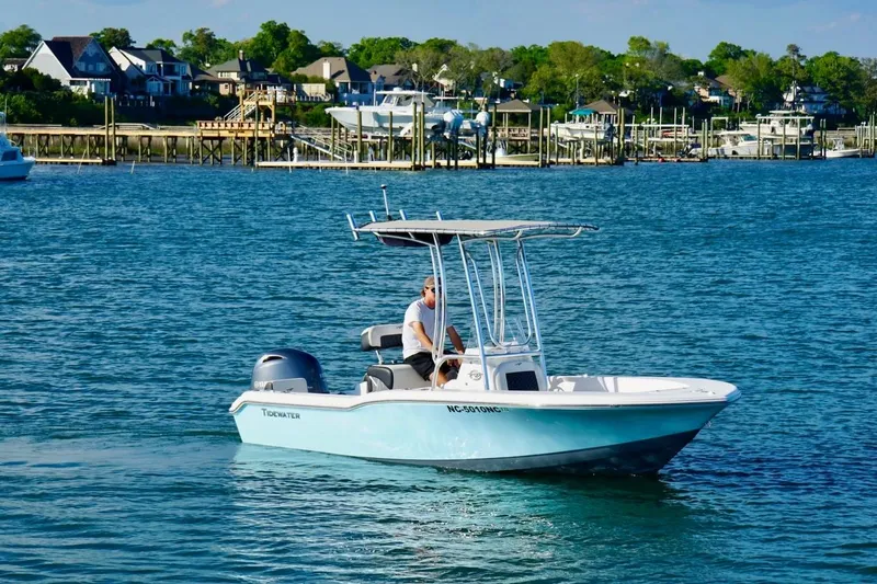 Slide: The Image of 2024 Tidewater 180 CC Adventure boat cruising on a scenic waterfront. - 5