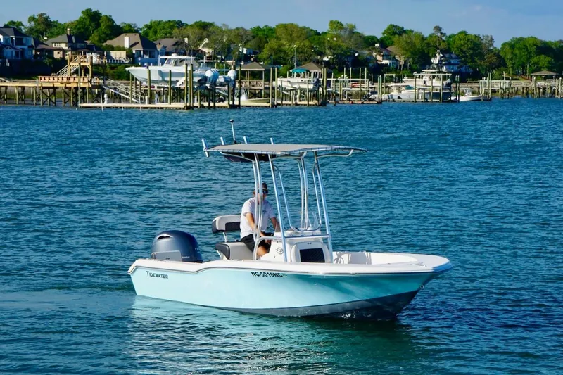 Slide: The Image of 2024 Tidewater 180 CC Adventure boat cruising on a scenic waterfront. - 6