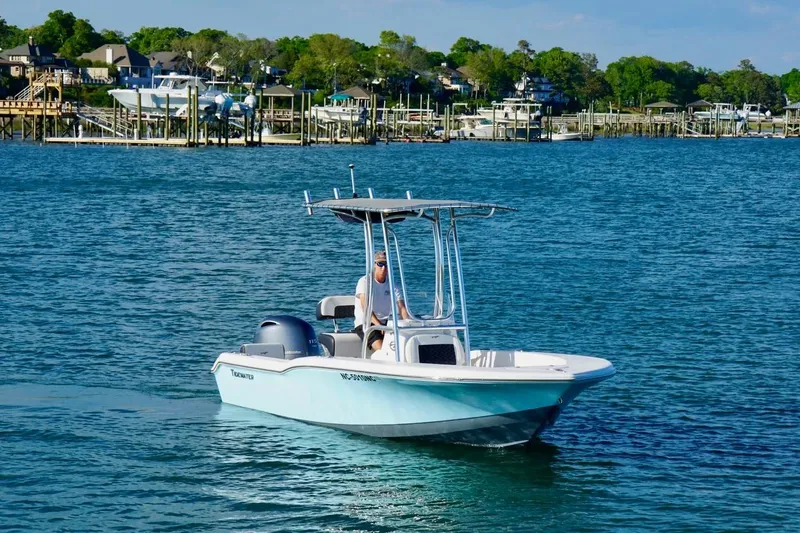 Slide: The Image of 2024 Tidewater 180 CC Adventure boat cruising on a scenic waterfront. - 7