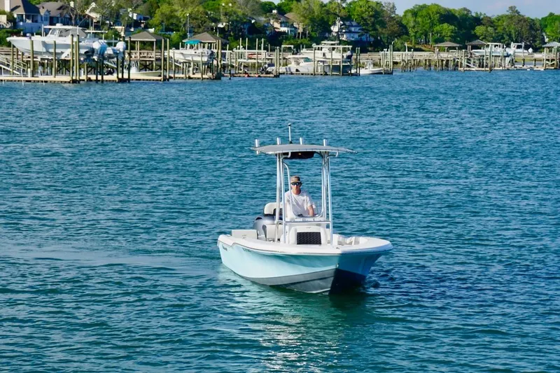 Slide: The Image of 2024 Tidewater 180 CC Adventure boat cruising on a scenic waterfront. - 9