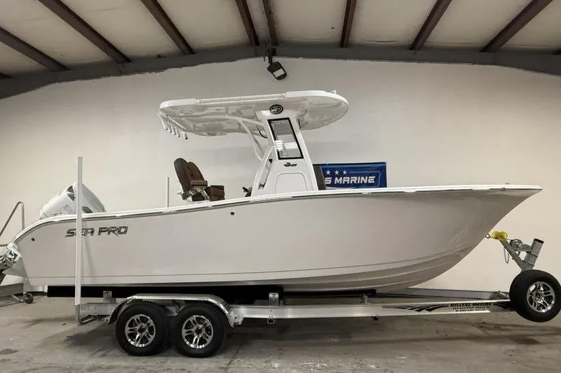 The Image of 2026 Sea Pro 242 Center Console boat on trailer in indoor storage. - 0