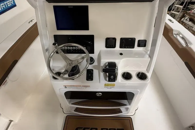 Slide: The Image of 2026 Sea Pro 242 Center Console helm with steering wheel and controls. - 17