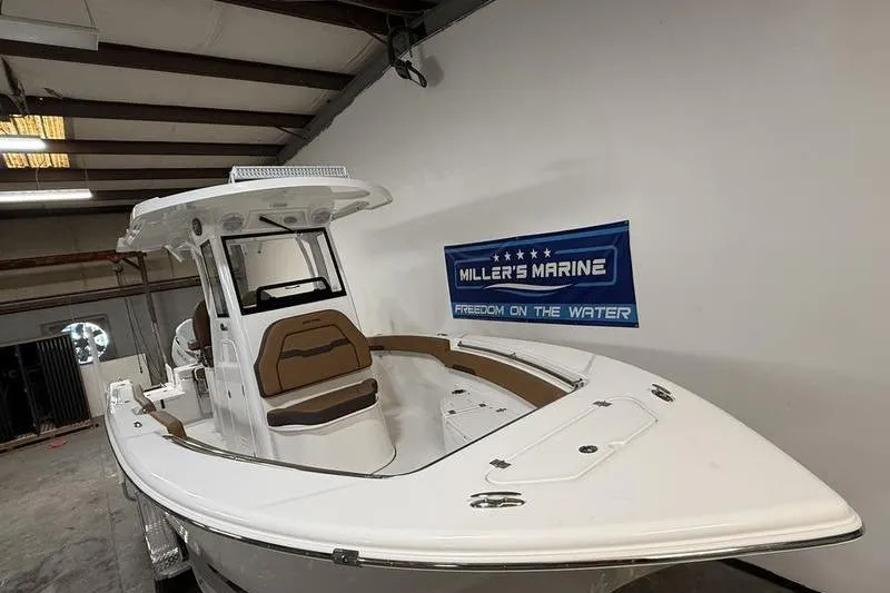 Slide: The Image of 2026 Sea Pro 242 Center Console boat displayed indoors at Miller's Marine. - 2