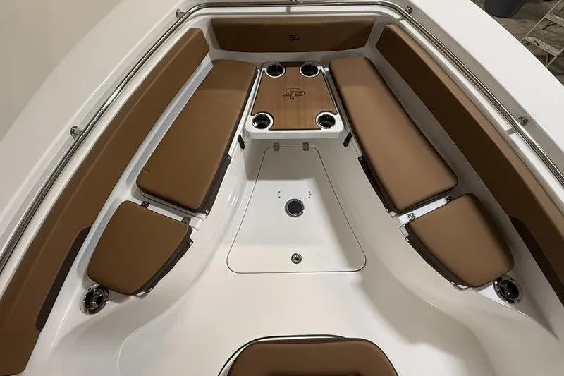 Slide: The Image of 2026 Sea Pro 242 Center Console boat interior with brown cushioned seating and cup holders. - 27
