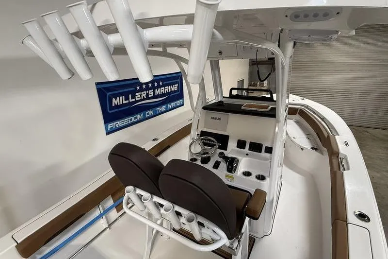 Slide: The Image of 2026 Sea Pro 242 Center Console boat interior with helm and rod holders. - 5