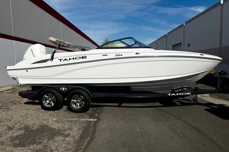 The Image of 2026 Tahoe 210 S boat on trailer, parked outdoors, side view. - 0
