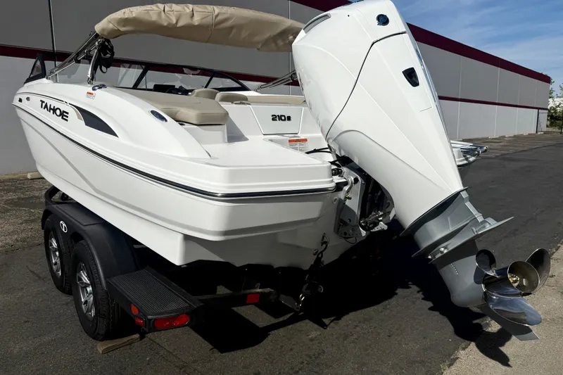 Slide: The Image of 2026 Tahoe 210 S boat on trailer, featuring sleek design and powerful outboard motor. - 11