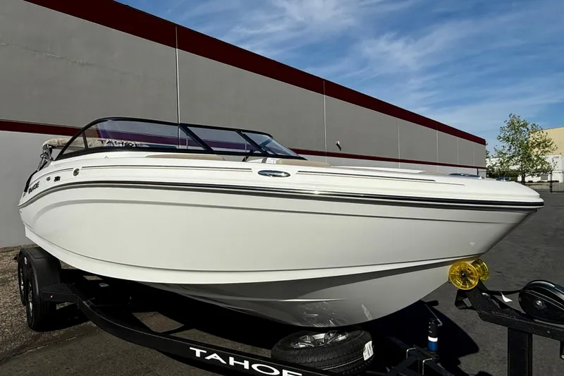 Slide: The Image of 2026 Tahoe 210 S boat on trailer, parked outdoors under clear sky. - 15