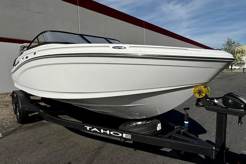 Slide: The Image of 2026 Tahoe 210 S boat on trailer, parked outdoors. - 17