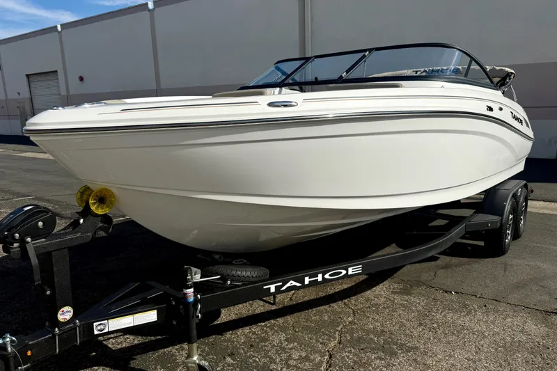 Slide: The Image of 2026 Tahoe 210 S boat on trailer, parked outdoors. - 2