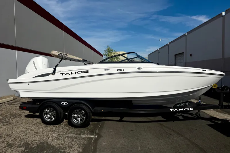 Slide: The Image of 2026 Tahoe 210 S boat on trailer, parked outdoors, side view. - 20