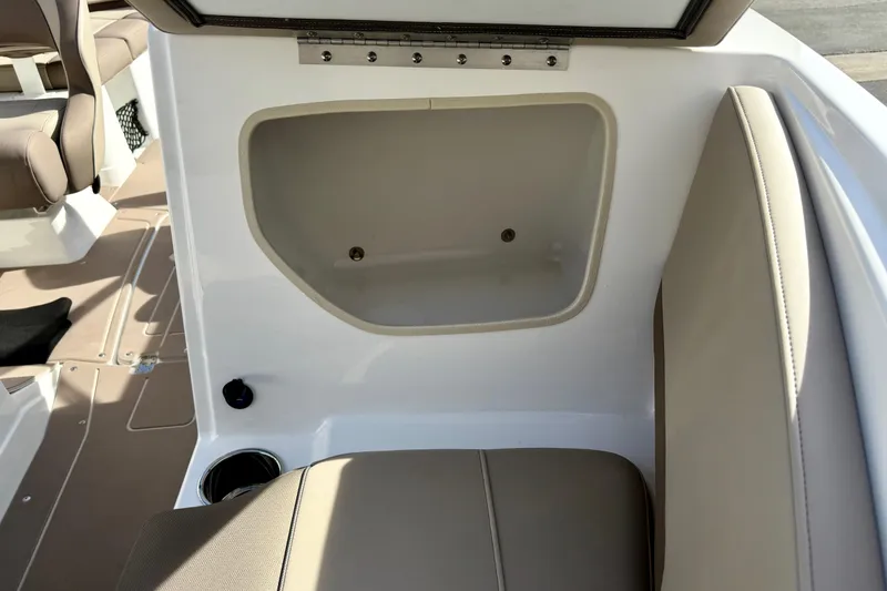 Slide: The Image of 2026 Tahoe 210 S boat interior storage compartment with beige seating. - 26