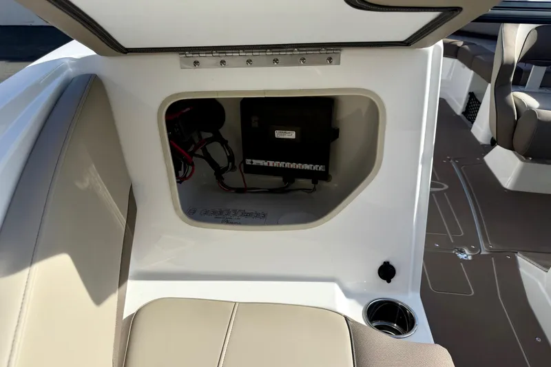 Slide: The Image of Open storage compartment in 2026 Tahoe 210 S boat, showcasing interior wiring and seating. - 27