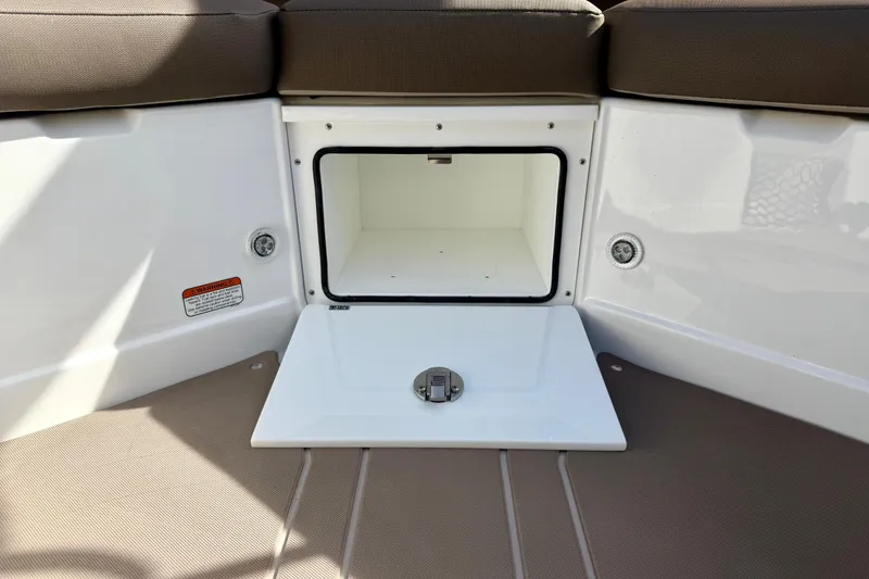 Slide: The Image of Storage compartment on 2026 Tahoe 210 S boat, featuring cushioned seating and open hatch. - 29