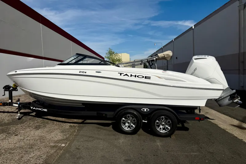 Slide: The Image of 2026 Tahoe 210 S boat on trailer, sleek design, white exterior, parked outdoors. - 3
