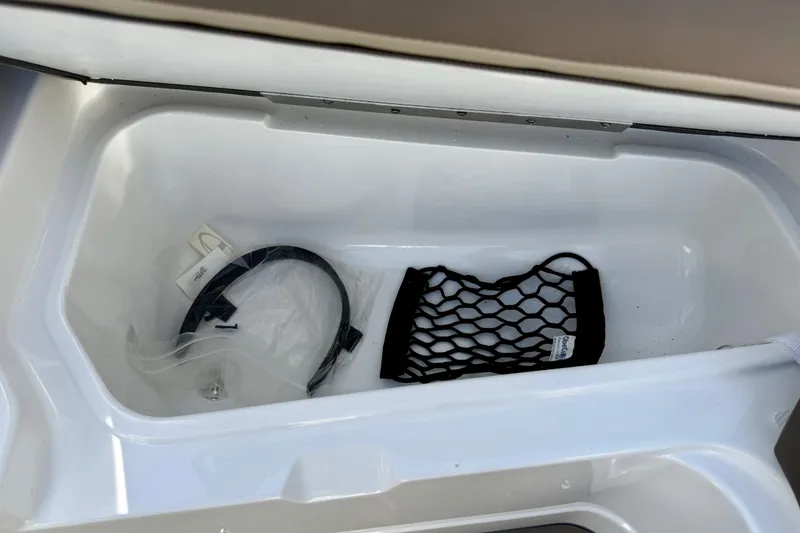 Slide: The Image of Storage compartment in 2026 Tahoe 210 S boat with netting and accessories. - 32