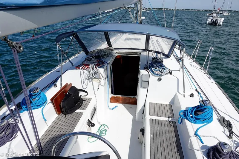 Slide: The Image of 2005 Beneteau First 44.7 sailboat cockpit with ropes and open cabin, on calm water. - 13