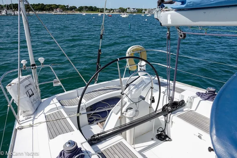 Slide: The Image of 2005 Beneteau First 44.7 sailboat cockpit with steering wheel, docked in a scenic marina. - 15