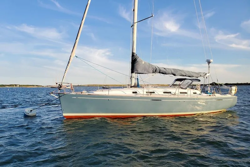 Slide: The Image of 2005 Beneteau First 44.7 sailboat on calm water under a clear blue sky. - 8