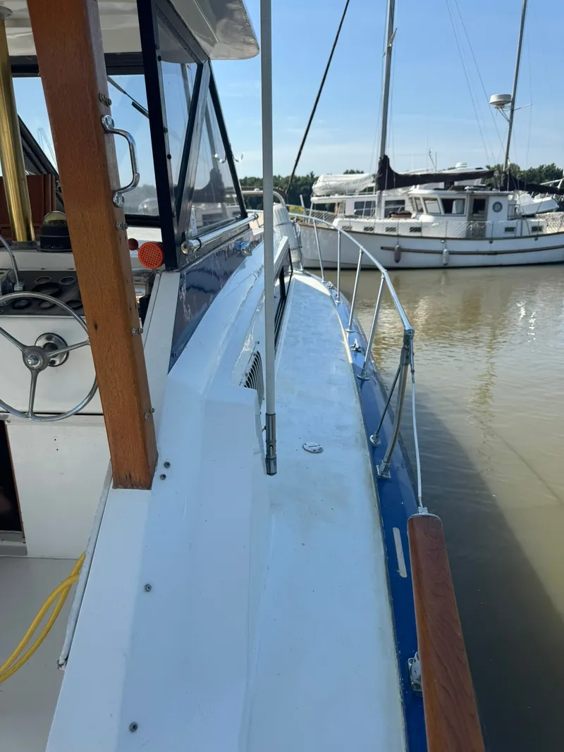 Slide: The Image of 1968 Hatteras 31 Flybridge yacht docked in harbor. - 10