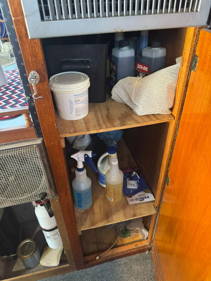 Slide: The Image of Interior of 1968 Hatteras 31 Flybridge with cleaning supplies in cabinet. - 19