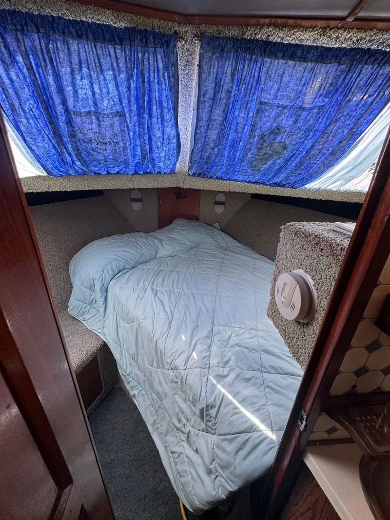 Slide: The Image of Interior of 1968 Hatteras 31 Flybridge with bed and blue curtains. - 22