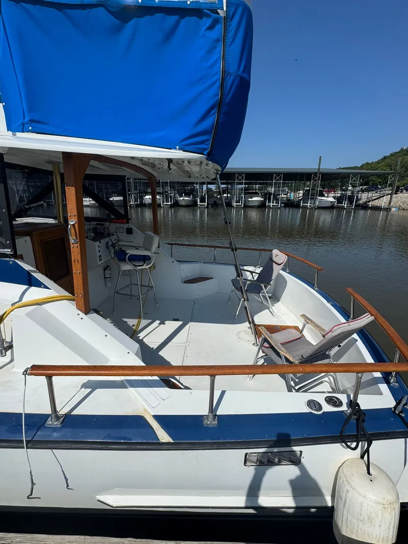 Slide: The Image of 1968 Hatteras 31 Flybridge boat docked with blue cover. - 4