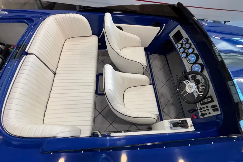 Slide: The Image of 2026 Donzi 22 Classic boat interior with white seating and blue dashboard. - 15