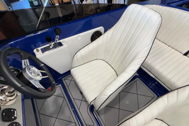 Slide: The Image of Interior of 2026 Donzi 22 Classic boat with white seats and steering wheel. - 19