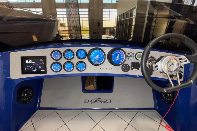 Slide: The Image of 2026 Donzi 22 Classic dashboard with gauges and steering wheel in a showroom setting. - 27