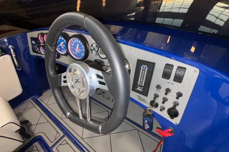 Slide: The Image of Steering wheel and dashboard of 2026 Donzi 22 Classic boat, featuring modern controls. - 28