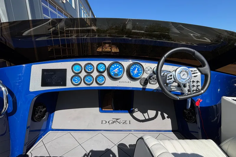 Slide: The Image of Dashboard of a 2026 Donzi 22 Classic boat with blue gauges and steering wheel. - 4