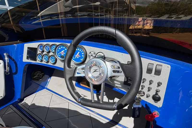Slide: The Image of 2026 Donzi 22 Classic boat dashboard with blue gauges and steering wheel. - 7