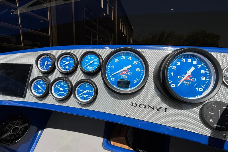 Slide: The Image of Dashboard of a 2026 Donzi 22 Classic boat with blue gauges and controls. - 8