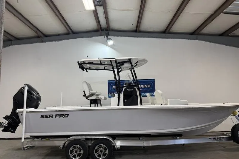 The Image of 2026 Sea Pro 250 Bay boat on trailer in indoor showroom. - 0