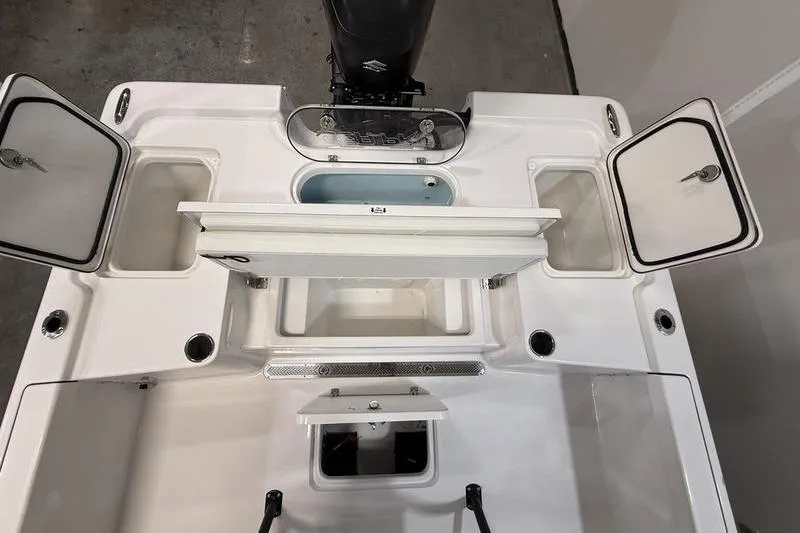 Slide: The Image of 2026 Sea Pro 250 Bay boat deck with open storage compartments and motor. - 8