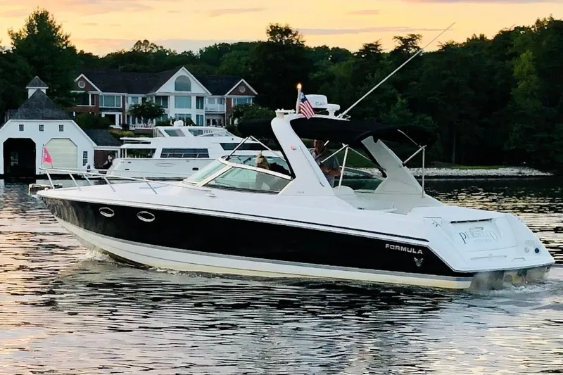 The Image of 2004 Formula 330 Sun Sport boat cruising on a scenic lake at sunset. - 0