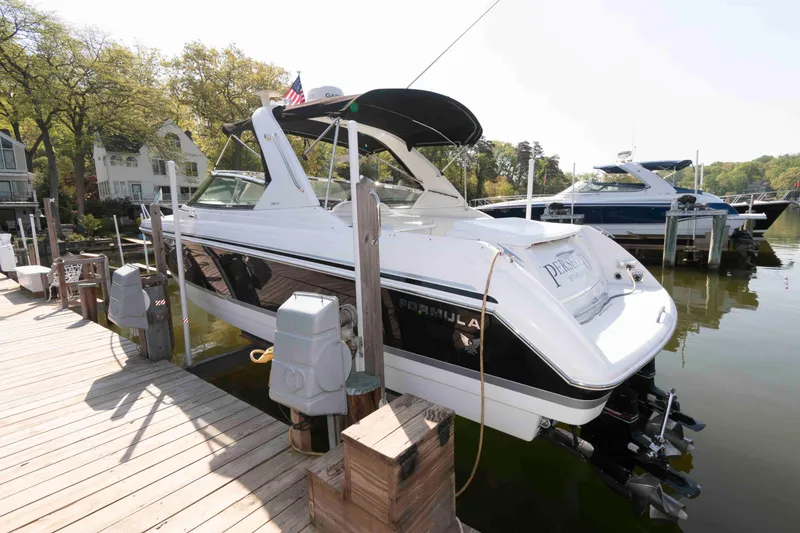 Slide: The Image of 2004 Formula 330 Sun Sport boat docked at a marina, surrounded by trees and water. - 3