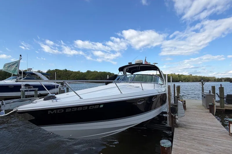 Slide: The Image of 2004 Formula 330 Sun Sport boat docked by a scenic lake under a blue sky. - 5