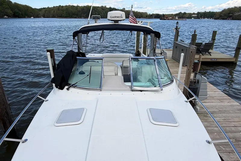 Slide: The Image of 2004 Formula 330 Sun Sport boat docked on a serene lake with clear skies. - 7