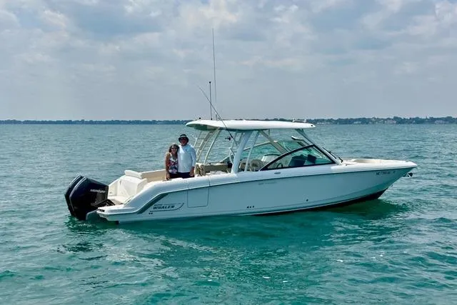 Slide: The Image of 2022 Boston Whaler 320 Vantage boat on calm blue water under a cloudy sky. - 3