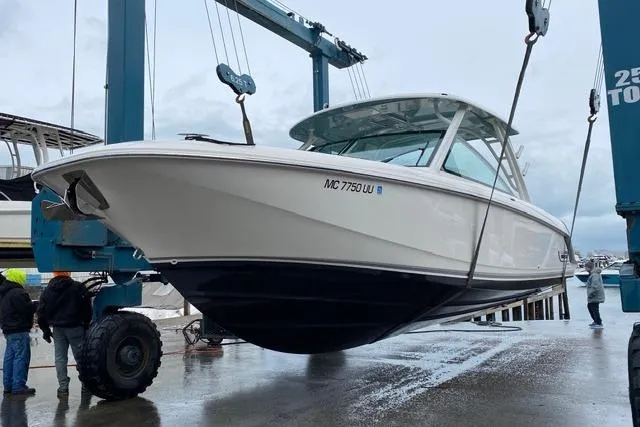 Slide: The Image of 2022 Boston Whaler 320 Vantage boat being lifted at a marina. - 5