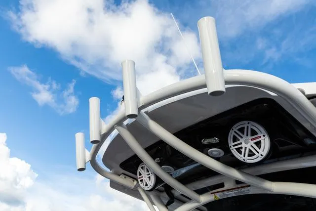 Slide: The Image of 2023 Wellcraft 222 Fisherman boat with rod holders and speakers against a blue sky. - 8