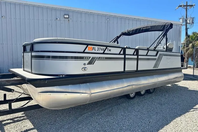 The Image of 2023 Viaggio Lago X-R 22 pontoon boat on trailer, parked outdoors. - 1