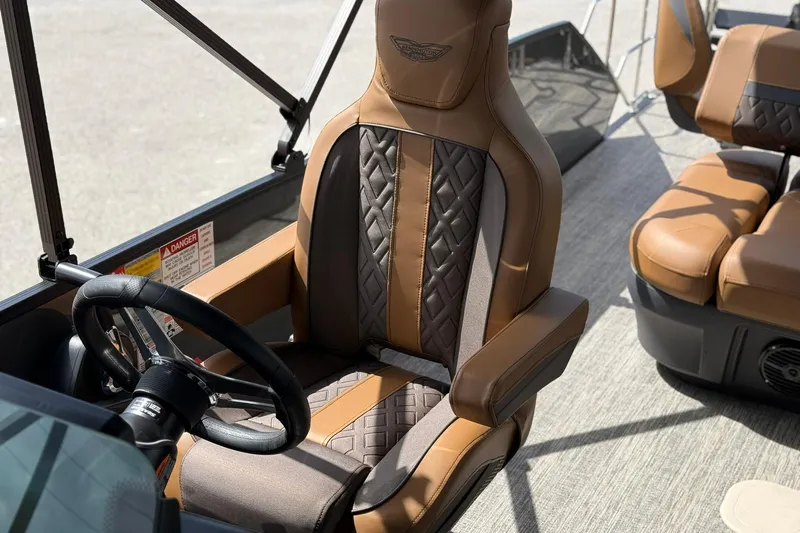 Slide: The Image of 2026 Bennington 24 M Fish and Cruise boat interior with luxurious brown seating and steering wheel. - 15