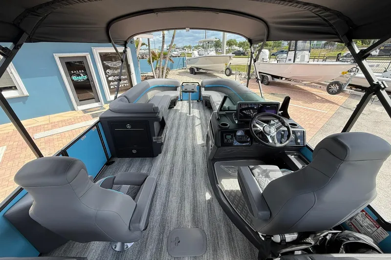 Slide: The Image of 2026 Bennington 26 M Quad Bench pontoon boat interior with modern seating and steering console. - 5