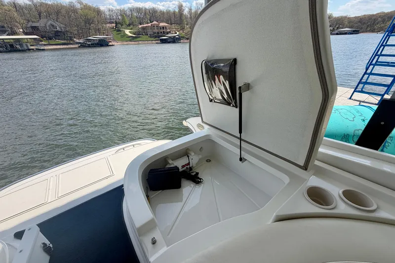 Slide: The Image of Open storage compartment on a 2003 Cobalt 282 boat by a scenic lake. - 12