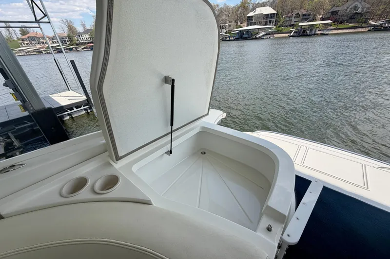 Slide: The Image of Open storage compartment on a 2003 Cobalt 282 boat by a lakeside dock. - 13